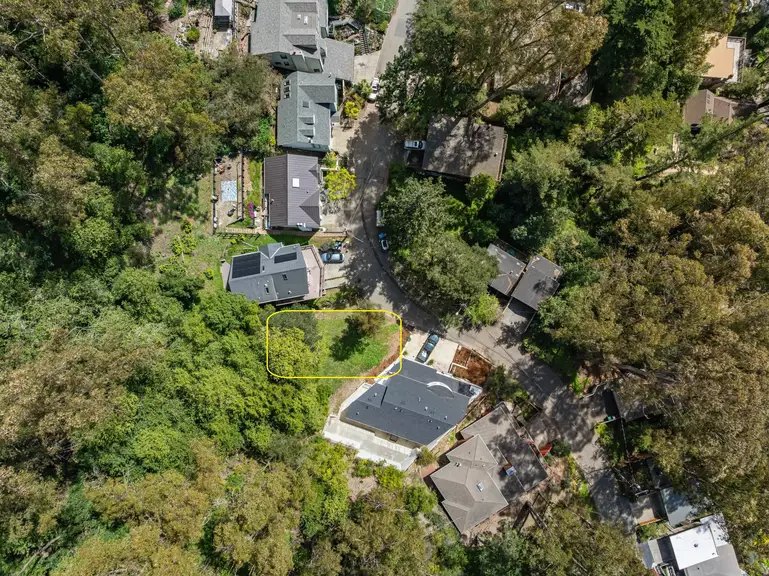 Aerial view of homes and trees with a highlighted vacant lot